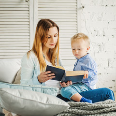 Happy Family at Home. Mom and her Son Reading a Book