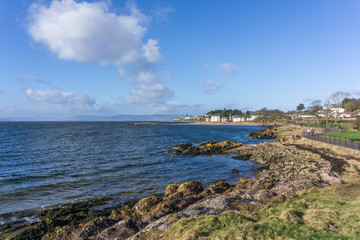 Fototapeta na wymiar The town of largs Scotland in the distance from the South shore on a cold but bright day. A good tourism image.
