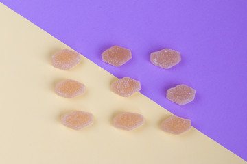 Yellow sweet marmalade with a yellow and purple background