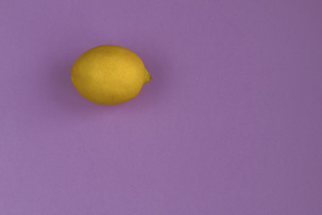 Top view on a frech yelloe lomon with a purple  background, flatlay