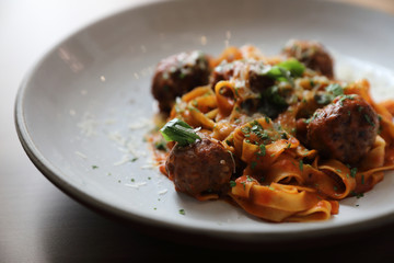 Spaghetti pasta with beef meatballs and tomato sauce on wood background . italian food