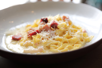 spaghetti carbonara white sauce with bacon on wood background in restaurant
