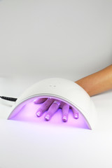 Manicure with uv led lamp, curing gel or hybrid varnish, manicure on table on bright...