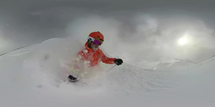 360VR man with beard skiing in deep snow on cloudy winter vacation day in mountains
