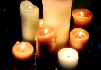 Burning candles on black background top view
