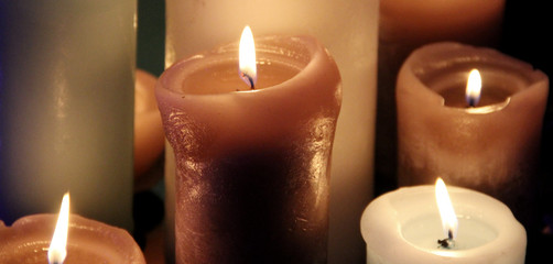 Candles flames over black background close up 

