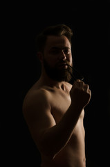 shirtless, handsome young man standing. Studio shot of light,