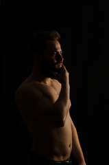 Fototapeta premium shirtless, handsome young man standing. Studio shot of light,