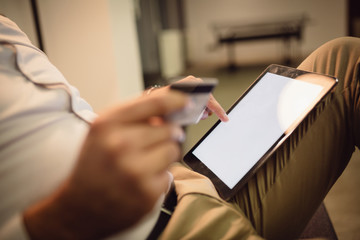 Close-up of male hands using tablet and shopping online.