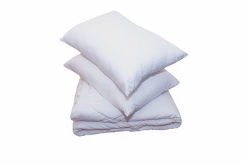 Roll of soft white blankets and white pillows isolated on white background