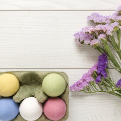Fototapeta na wymiar uova di pasqua bianche o colorate confettate con fiori su fondo bianco