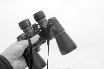 binoculars in hand black and white