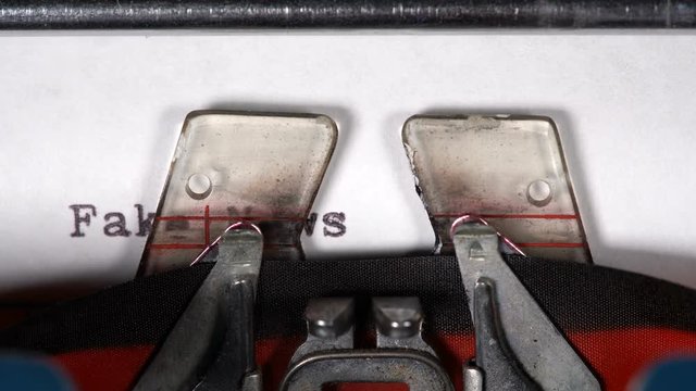 Macro detail of the type of electric typewriter with ribbon typing Fake news