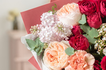 bouquet of highly red coloured . beautiful luxury bunch of mixed flowers in womans hand. the work of the florist at a flower shop.