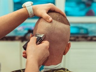 Barber cuts your head electric razor. Man haircut in the barbershop.