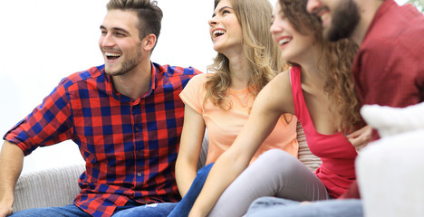 group of cheerful friends sitting on the couch