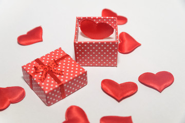 Red heart in a gift box on a white background with lots of red little hearts concept love