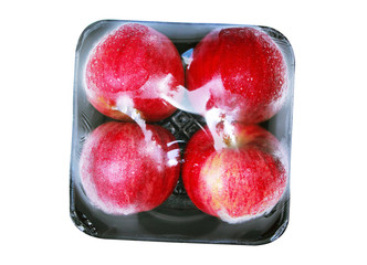 Apple wrapped in transparent plastic isolated on white background.