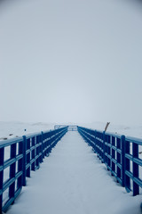 Blue boardwalk on snowy day