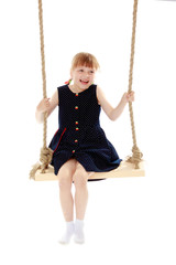 Little girl swinging on a swing