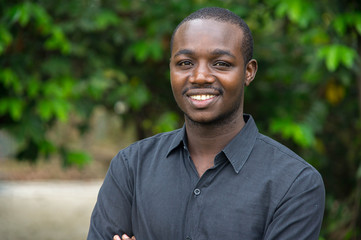 African business man looking and smiling in green nature background.