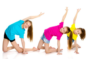 A group of girls gymnasts perform exercises.