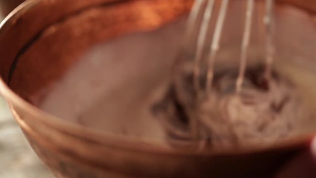 Wire whisk mixes ingredients in mixing bowl, slow motion