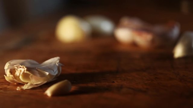 Pan left, unpeeled garlic clove crushed by knife