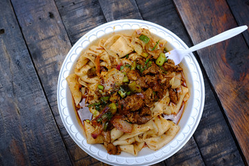 Freshly made Chinese wheat thick noodles on a stylophone plate. 