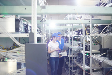 Man and woman on the farm for the extraction of crypto currencies. Bitcoin mining