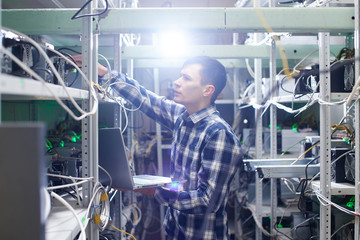 Mining. A man working on a farm for the extraction of crypto currencies. Bitcoin business