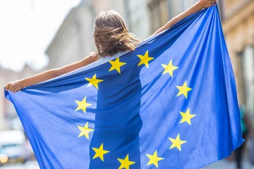 Foto op Plexiglas EU Flag. Cute happy girl with the flag of the European Union. Young teenage girl waving with the European Union flag in the city © weyo