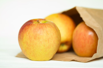 fresh ripe apples in a paper package on a white backgroung