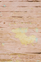 Textured background of multi-layer flaking paint on the wall. Mixing different colors of paints in the cleaved layers on the surface. Grunge texture with a deep pattern