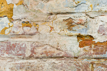 Close-up Textured background of multi-layer flaking paint on the wall. Mixing different colors of paints in the cleaved layers on the surface. Grunge texture with a deep pattern
