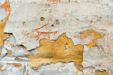 Close-up Textured background of multi-layer flaking paint on the wall. Mixing different colors of paints in the cleaved layers on the surface. Grunge texture with a deep pattern