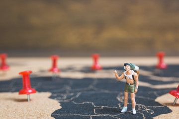 Miniature people backpacker walking on world map, Tourism and travel concept