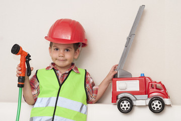 child in a red helmet and with a fire engine