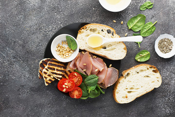 Appetizing snack with fried cheese haloumi, olives, bruschetta, tomatoes, olives, pine nuts, olive oil, honey and spinach. Top View