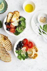Cheese haloumi brown rice bowl with tomatoes, olives, lemon and pine nuts. Top View