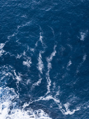 Aerial view of blue water and white foam.