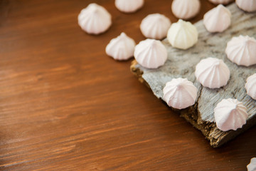 lots of little meringues on dark wooden background