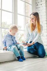 Happy Family. Young Woman and Little Child Boy with Wooden Toys at Home