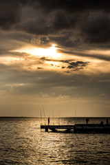 Fisherman silhouette with sunset sky at the sea