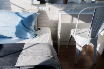 Bed maid-up with clean white  pattern pillows and bed sheets in beauty room. Close-up. Lens flair in sunlight.