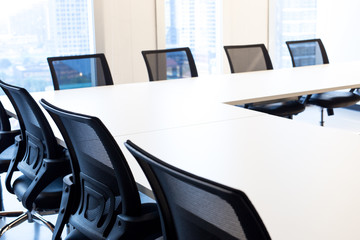 Modern meeting room with large windows, view back chair, outside building, city, tower view, soft focus.
