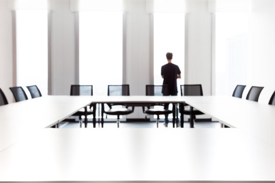 A Man, Boss, Looking Outside A Window, Room, Office. Abstarct Photo. Defocused. Blurred Background.