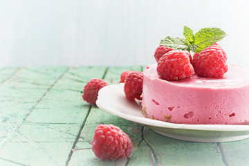 Raspberry  cheesecake (cream mousse cake) on  wooden background, copy space.