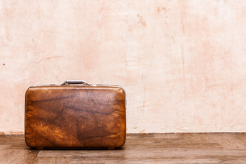 Vintage brown traveling luggage on wall background. Travel suitcases concept