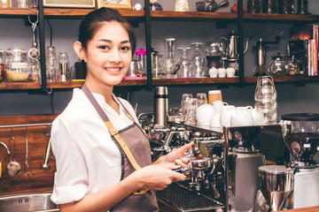 Women Barista using coffee machine for making coffee in the cafe